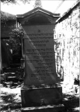 Grabstein 176 (Index: 100094332) Material: Sandstein Zustand: gut Maße HxBxT: 187x75x40 cm Beschreibung: kon. Stele, getreppt. Sock, eingezog. giebelart. Abschl. m. Verdach. u. Mittelakroter Symbolik: Blätter im Akroter Besonderheit: gereimter 8-Zeiler; - Zit.Spr.12, 4: Grabstein 176