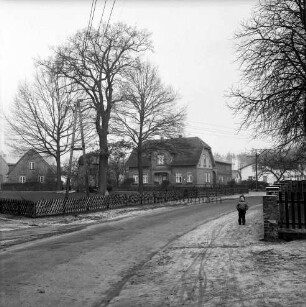 Tremsbüttel-Dorf: Dorfplatz mit Ehrenmal: dahinter Bauern- und Wohnhäuser: vorn Dorfstraße: rechts Kind auf Fußgängerweg