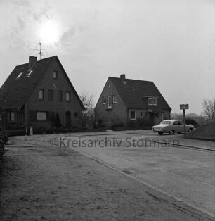 Lorentzenstraße: vor Ausbau: Abrisshäuser mit Garten: rechts Straßenschild und parkender Pkw