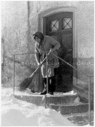 Frau kehrt Schnee vor der Tür (Altersgruppe 14-17)