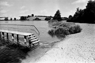 Moorteich: Badestelle mit Sandstrand, Steg und Schilf: am gegenüberliegenden Ufer Knicklandschaft: 9. August 1999