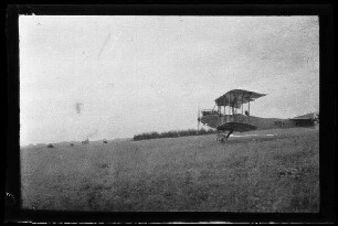 Nicht identifizierbare Ortschaft in Nordfrankreich oder Belgien: Doppeldecker auf einem Feld (Seitansicht)