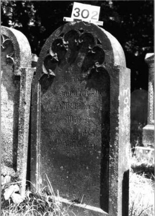 Grabstein 302 (Index: 100085252) Maße HxBxT: 127x62x14 cm Beschreibung: Stele, eingezogener Rundbogenabschluß, Schriftfeld eingetieft: Grabstein 302