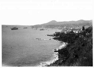 Funchal, Madeira. Blick entlang der Küstenlinie auf Stadt und Hafen mit Hochseepassagierdampfer "Cleveland" auf Reede