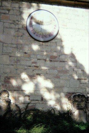 Sonnenuhr und Grabsteine an der Kirchenaußenwand der Blasiuskirche