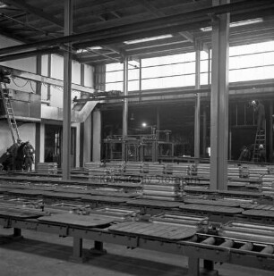 Gießtechnik Nord GmbH: Kampstraße: Eisengießerei: [Fabrikkomplex ehemals Eisengießerei Kampnagel AG]: Innenaufnahme: neue Werkhalle: Anlagen im Aufbau: hinten links Fachleute bei Besichtigung, rechts Arbeiter auf Leiter bei Schweißarbeiten