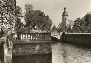 Zabeltitz, Schloss, Blick von der Terrasse vor dem Palais über den Wassergraben (Gänseröder) zur Dorfkirche