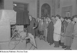 Besucher an einem Ausstellungsobjekt (Produktionsmaschine) im Sowjetischen Pavillon