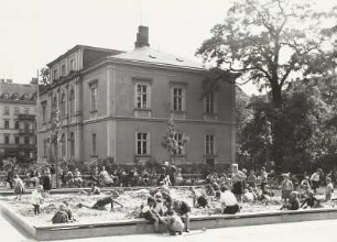 Dresden-Altstadt, Marienstraße. Kinderspielplatz und Mietvilla. Sandkasten in der Grünanlage. Im Hintergrund Wohn- und Geschäftshaus Ringstraße 2 mit Firma Max Franz Rost (Möbelstoffe, Dekorations- und Polsterbedarf)