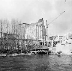 Johannes Ströh Mühlenwerke: Weizenmühle ("Gloria-Mühle"): am Pferdemarkt: Erweiterung: neues Silo in Bau, oben mit Gerüst: davor Lagerhalle in Bau, mit Gerüst: Baukran: hinten gemauertes Silo: rechts Gewerbegebäude: vorne Travearm, "Schleusenkuhle", Bildmitte Mühlendurchfluss