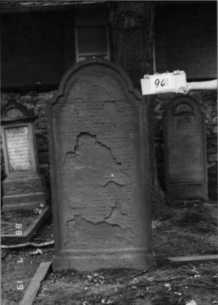 Grabstein 96 (Index: 100094804) Material: Sandstein Zustand: abgeblättert mit Textverlust Maße HxBxT: 168x75x19 cm Beschreibung: Stele, doppelt eingezogener Rundbogenabschluß, Schriftfeld eingetieft: Grabstein 96