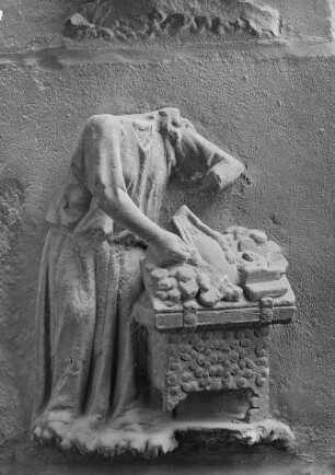 Südliches Westportal — Südlicher Türpfosten — Weibliche Gestalt neben einer Geldkasette (i 5)