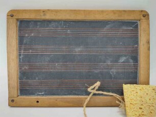 Schiefertafel mit Notenlinien und Schwämmchen