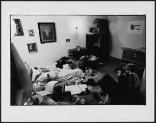 Susan Lamèr in einem Zimmer auf einer Matratze sitzend