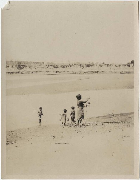 Choroti woman fetching water from the Rio Pilcomayo with her children