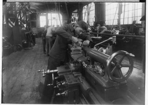 Reichsberufswettkampf ¿ Metall 1934; Feinmechaniker beim Fräsen in einer Werkshalle Laucherthal; im Hintergrund weitere Personen bei der Arbeit
