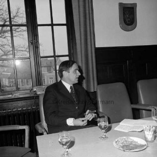 Rathaus: Neujahrsempfang: geschäftsführendes Vorstandsmitglied des Städtebundes Schleswig-Holstein Magnus Staack am Tisch, mit Zigarre