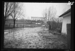 Wirballen (=Virbalis, Litauen): morastiger Weg mit katholischer Kirche im Hintergrund
