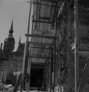 Stralsund. Eingerüstetes Haus, im Hintergrund Nikolaikirche
