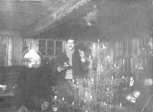 Hans Richter auf einer Sonnenwendfeier in einem Blockhaus. Ansicht mit Weihnachtsbaum
