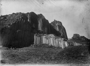 Basaltsäulen am Herrenhausfelsen : Blick über eine Wiese auf die Basaltsäulen am Herrenhausfelsen