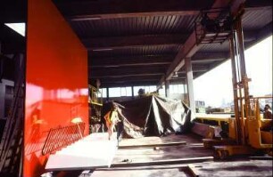 Werbeaufnahmen an einem Set mit Treppe, Geländer und rotem Hintergrund für Müssig AG