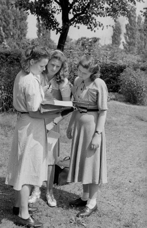 Schulentlassung von Abiturientinnen : Porträt von Abiturientinnen mit ihren Abschlusszeugnissen