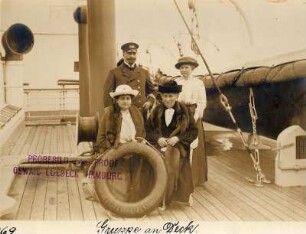 Nordlandreise, IV. Drei Damen und ein Herr in einem Gruppenbildnis neben den Rettungsbooten an Deck der Victoria Luise