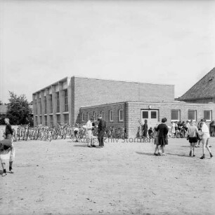 Sachsenwaldschule Gymnasium Reinbek: Schulstraße: Erweiterungsbau: Einweihung: vorn Schüler auf unbefestigtem Schulgelände: links Fahrräder: hinten links Turnhalle: hinten rechts Verbindungsbau: dahinter Altgebäude