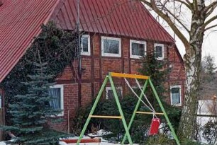 Hauptstraße 44: Bauernhaus aus Fachwerk: Giebelseite Wohntrakt, mit Kletterpflanzen: vorne Garten, Kinderschaukel