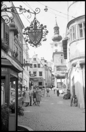 Salzburg: Blick in die Kirchgasse vom See aus, mit Aushängeschild [einer Weinstube]