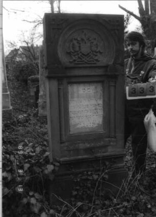 Grabstein 333 (Index: 100093087) Maße HxBxT: 195x65x30 cm Symbolik: Wappenschild mit Verzierungen, Säulen, Verzierungen: Grabstein 333