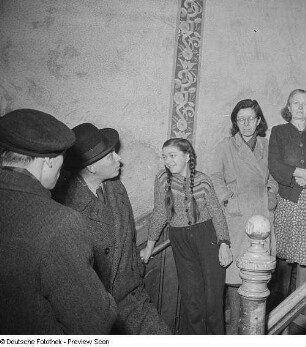 Bewohner eines Hauses im Treppenhaus bei einer Hausversammlung