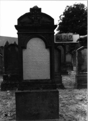 Grabstein 279 (Index: 99797806) Material: Sandstein, weiß, Marmorplatte Zustand: gut Maße HxBxT: 166x60x22 cm Beschreibung: Stele, Rundbogenaufsatz rechteckig erhöht, getreppter Sockel Symbolik: Mohnpflanze Steinmetz: Henne: Grabstein 279