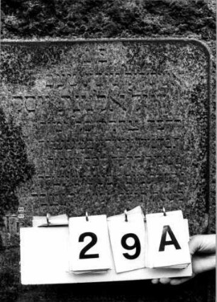 Grabstein 29 (Index: 100110180) Material: Granit, schwarze Marmorplatte Zustand: gut Maße HxBxT: 162x87x45 cm Beschreibung: felsenartige Stele, Schriftplatte, rechteckig: Grabstein 29A
