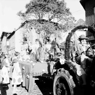 Karpfenfest: Umzug: Ahrensböker Straße: Festwagen, Neptun mit Nymphen und Seepferdchen, gezogen von Traktor, Begleiterinnen: im Hintergrund Zuschauer, Bildmitte Hotel Stadt Hamburg, Baum, rechts Einmündung von Paul-von-Schoenaich-Straße, 11. Oktober 1959