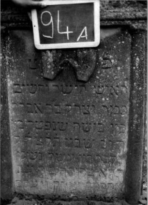 Grabstein 94 (Index: 100111195) Material: Sandstein Zustand: leicht verwittert Maße HxBxT: 103x62x14 cm Beschreibung: ädikulaartige Stele mit Halbsäulen, giebelartiger Abschluß mit Verdachung Symbolik: segnende Hände: Grabstein 94A