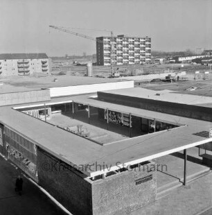 Klosterbergen: Blick von Wohnblock Richtung Nordosten auf neuen Stadtteil: vorn Straße Am Ladenzentrum: dahinter Sachsenwald-Einkaufszentrum: hinten links Wohnblock an der Bogenstraße: hinten Mitte und rechts mehrgeschossiges Punkthaus und Reihenhäuser an der Klosterbergenstraße: dazwischen Baustelle der evangelischen Nathan-Söderblom-Kirche mit Baukran