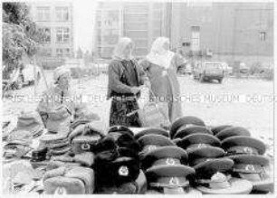 Serie: Mauerfall/Deutsche Einheit: Türkinnen an einem Souvenirstand mit Mützen der Sowjet-Armee