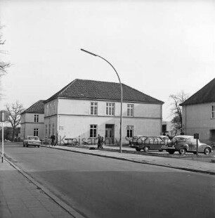 Stadtschule: Altbau: Königstraße: rechts Parkplatz mit Pkws: in der Mitte drei Personen: hinten links Pkw, Baum, Verkehrsschild: 09.11.1972