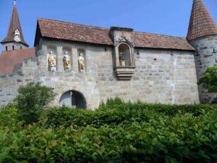 Ansicht von Süden (über Ortsseite) mit Torbau sowie Kirchhofmauer mit (rekonstruiertem) Wehrgang bis zum Südost-Rundturm