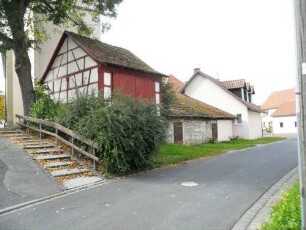 Ansicht von Ostsüdosten mit Basis der Kirchhofmauer (Wehrgang und Höhe im 19 Jh abgetragen) mit teils neuzeitlichen Gaden in Fachwerk