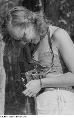 Junge Frau mit zweiäugigem Fotoapparat