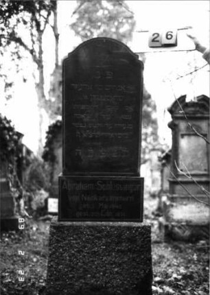 Grabstein 26 (Index: 99751728) Material: Granit Zustand: gut Maße HxBxT: 164x44x17 cm Beschreibung: Stele, getreppter Sockel, eingezogener Segmentbogenabschluß Symbolik: Davidstern: Grabstein 26