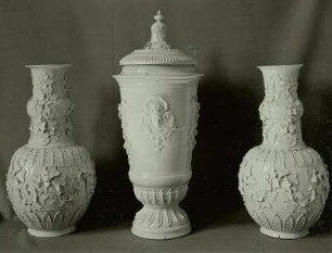 Zwei große Vasen mit plastisch aufgelegtem Weinlaub, eine hohe Deckelvase mit aufgelegter Ornamentik