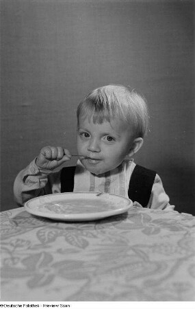 Ein Kind beim Verzehr von Nudelsuppe