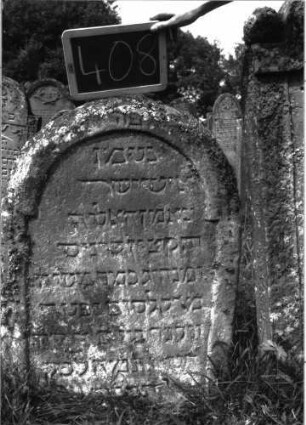 Grabstein 408 (Index: 100102807) Material: Sandstein Zustand: leicht bis stark verwittert Maße HxBxT: 90x57x12 cm Beschreibung: Stele, eingezogener Rundbogenabschluss, Schriftfeld eingetieft mit eingezogenem Rundbogenabschluss Besonderheit: kulturhistorisch wertvoll / hist.-wiss. Gründe (Vorsteher, Aluf, Kazin): Grabstein 408