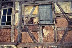Detail des Schulzenhauses: Holzschiebeladen, daneben altes Fenster