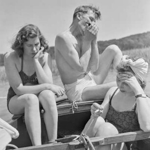 Elisabeth Gremmler (rechts) und ein befreundetes Paar sitzen auf einem Segelboot, der Mann spielt Mundharmonika