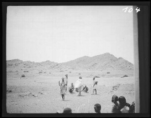 zwischen Mehesso (=Mieso (Äthiopien) und Dschibuti (Stadt) (Dschibuti): Einheimische ("Somali") auf Ödland, im Hintergrund kahle Bergrücken